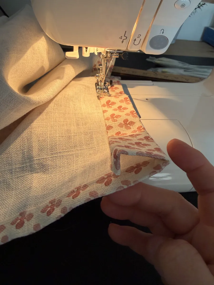 Showing how to fold fabric to sew a seam