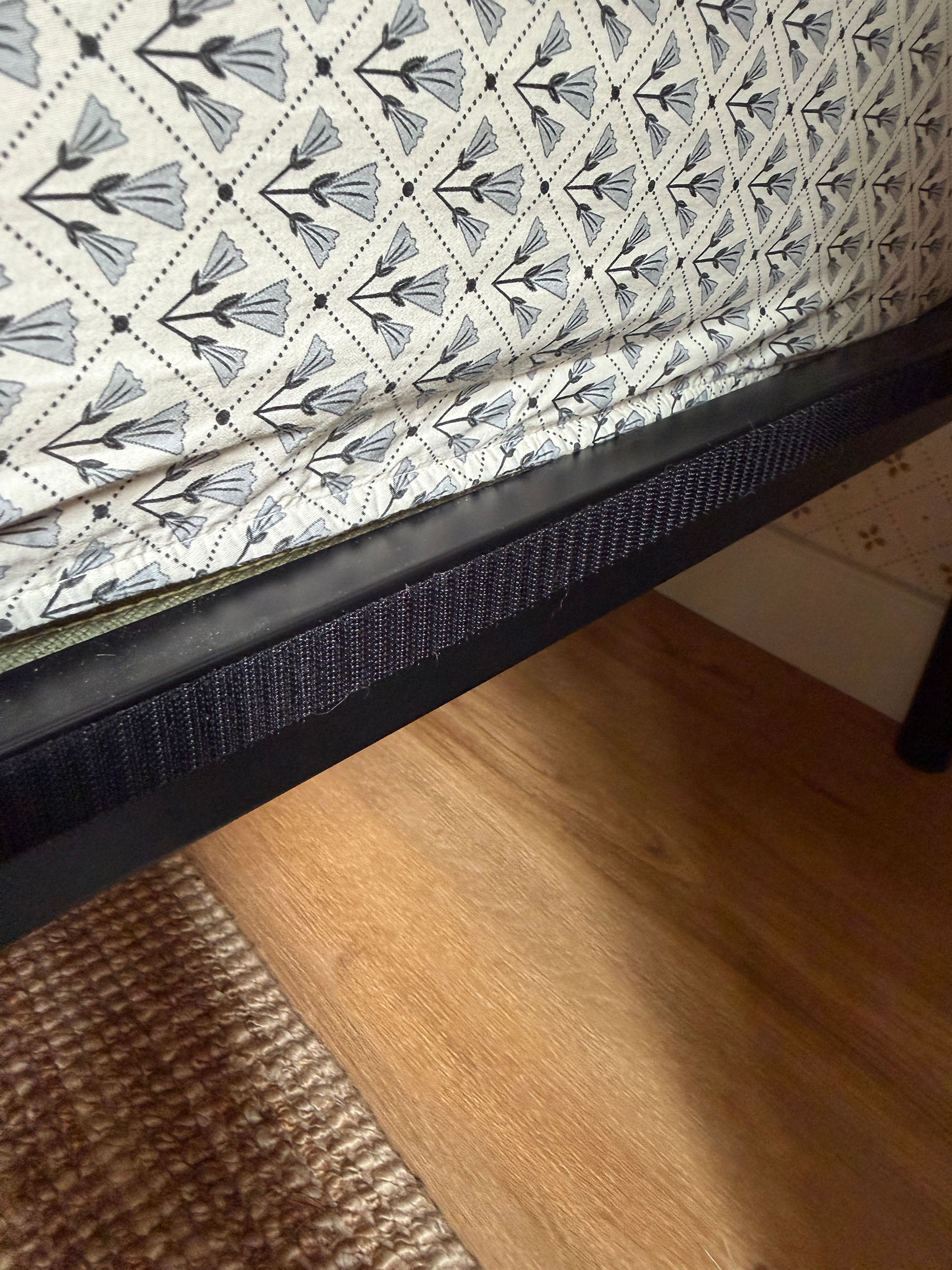 one side of sticky velcro attached to a black bed frame