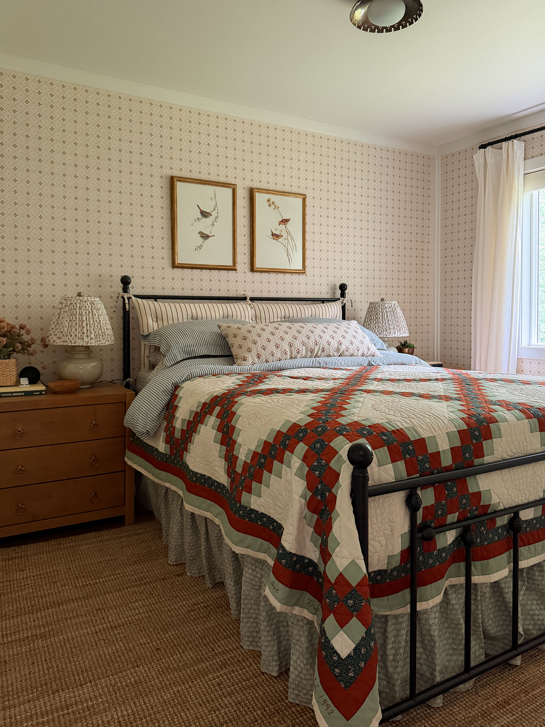 Bedroom with vintage quilt, DIY bedskirt, wallpaper and jute rug