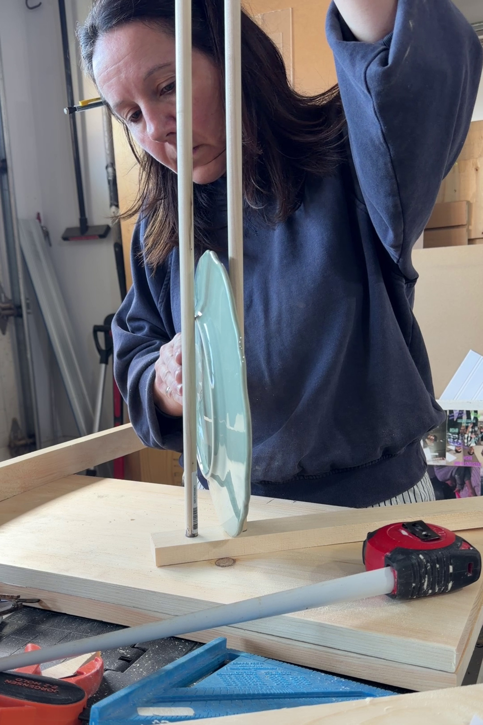 Girl holding plate between two dowels