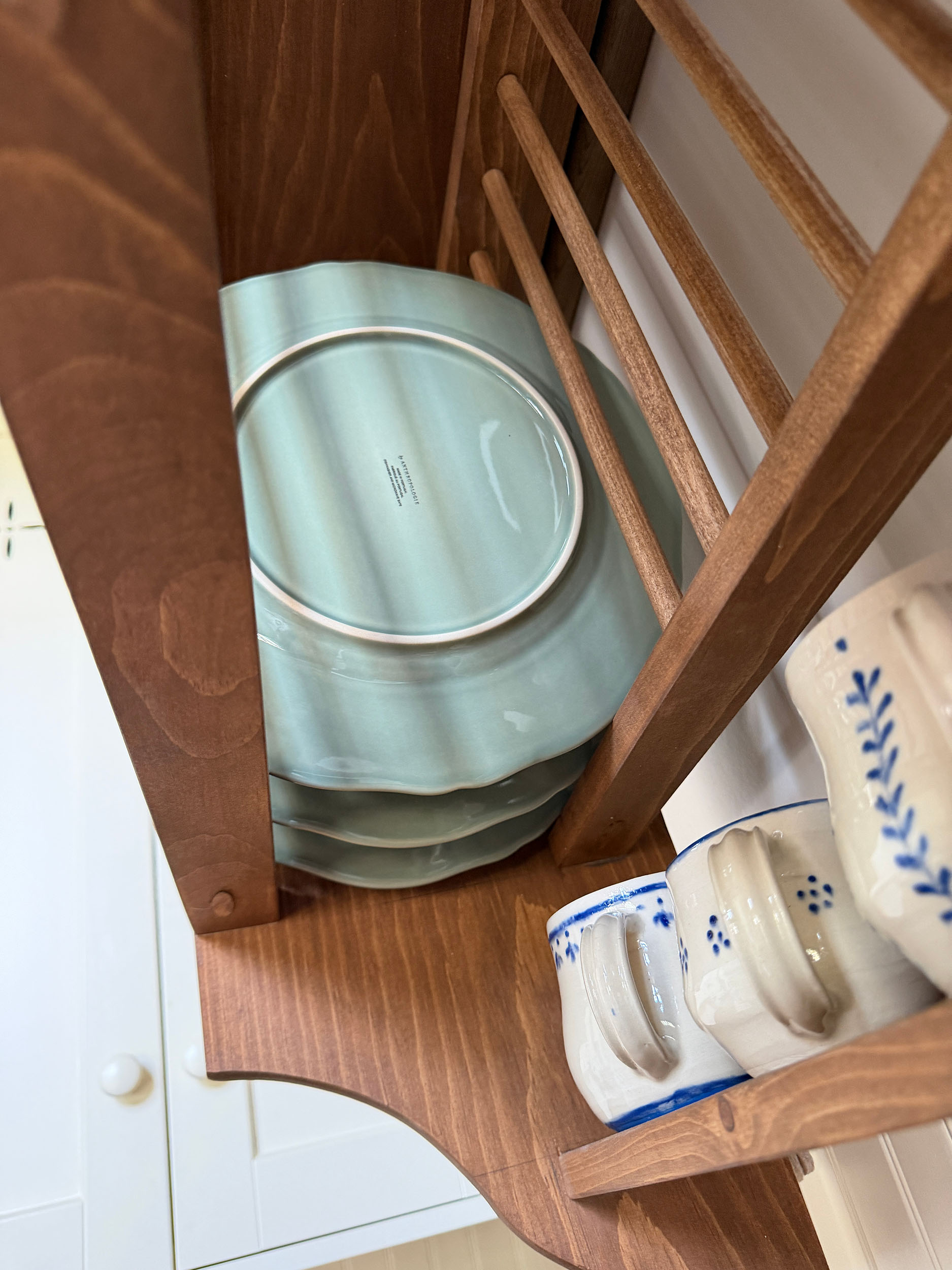 Underside of DIY plate rack showing plates sitting in the slats
